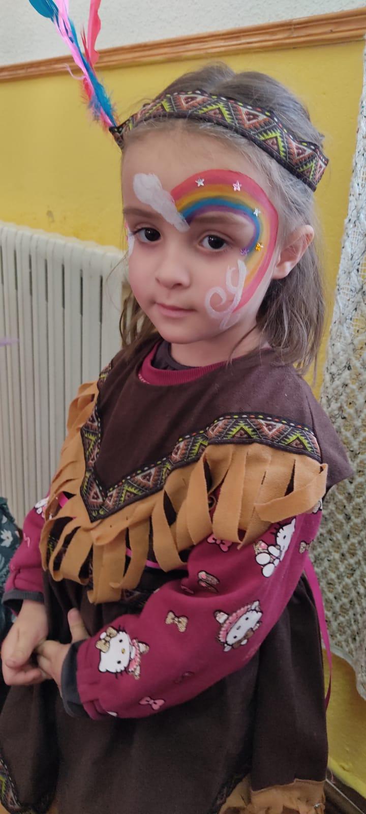 Niña con maquillaje carnavalesco de arcoíris en la cara.